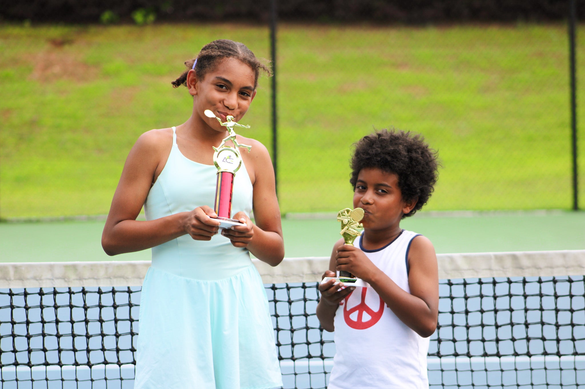 Junior tennis champions holding trophies at Emperial Tennis event